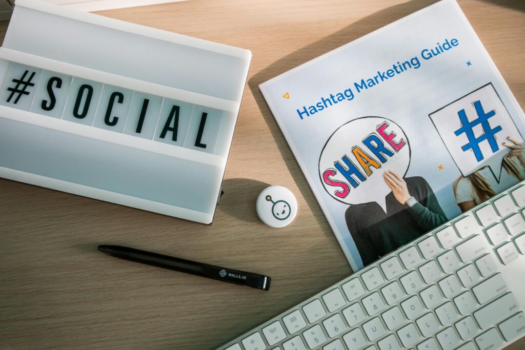 Gestor de Redes Sociais: O Que Faz, Quanto Ganha e Como Virar Um A desktop setup with social media marketing essentials including a keyboard, lightbox, and guide.