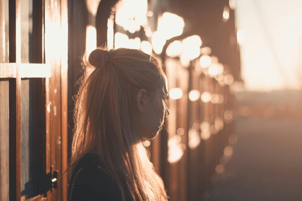 Silhouette of a woman with long hair against a sunset backdrop in Póvoa de Santa Iria, Portugal.