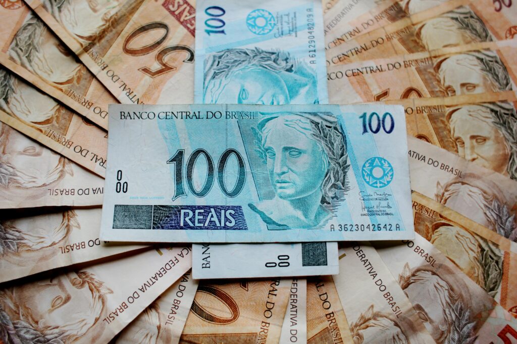 Previdência Social em 2026: Novas Regras e Como se Preparar Close-up of Brazilian Real banknotes featuring different denominations and intricate designs.