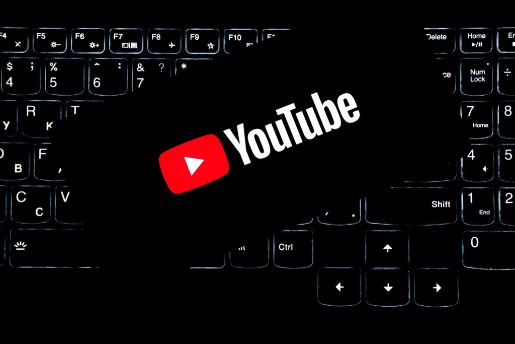 Como Criar Um Canal no YouTube e Monetizar em 2026 YouTube logo displayed on a backlit keyboard, representing digital media and online content creation.