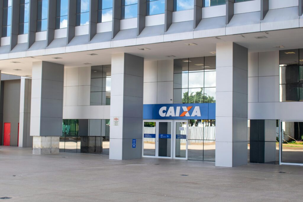 Como Usar o FGTS a Seu Favor (Muita Gente Não Sabe Disso) Entrance of a modern Caixa bank building in Brasília showing architectural details.