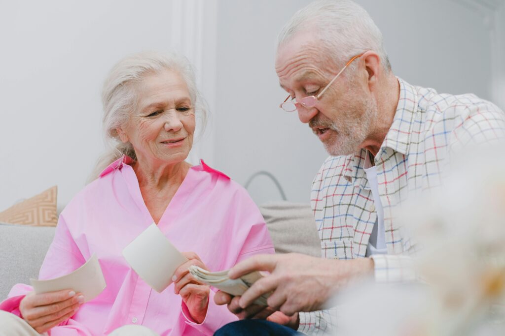 Senior couple enjoying time together while looking at photographs, smiling and reminiscing.