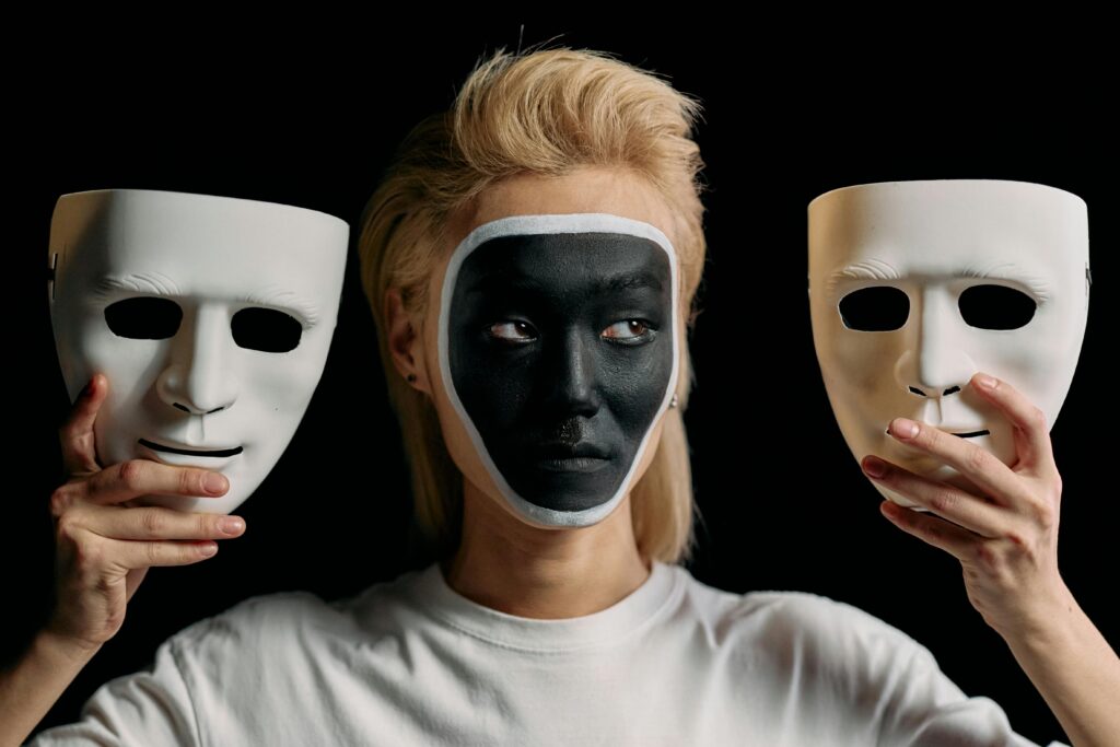 Síndrome do Impostor: Por Que Pessoas Competentes Se Sentem Incapazes Conceptual studio portrait showcasing art makeup with masks, blending creativity and mystery.