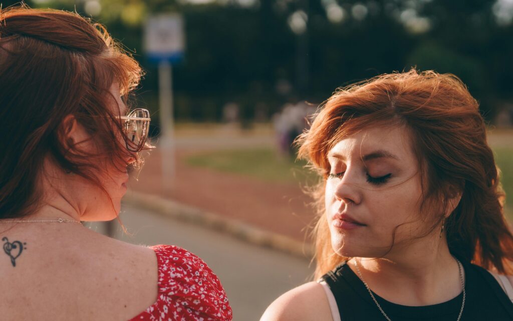 Two redheaded women in an outdoor setting enjoying a sunny day together.
